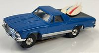 Front three-quarter view of blue Aurora El Camino HO slot car with surfboard