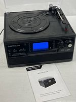 Front and top view of DigitNow! M503 unit with dust cover open and manual displayed