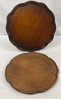 Both wooden platters front view showing size difference and finishes
