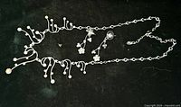 Full view of necklace and earrings laid flat showing design and components