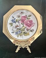 Front view of brass plate on stand showing floral porcelain insert