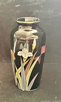 Front view of black ceramic vase showing multicolor iris design