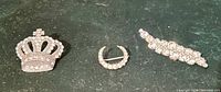 Front view of all three pins: crown, crescent, leaf