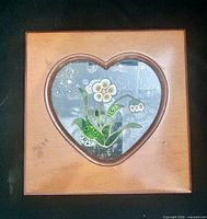 Closed wooden jewelry box showing heart glass inset with floral design