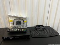Front view showing receiver, remote, bagged small devices, keyboard and accessories