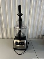 Full view of assembled food processor showing base, bowl, lid and pusher