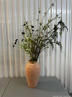 Full view of terracotta vase with faux floral arrangement