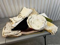 Entire pile of assorted vintage linens on table