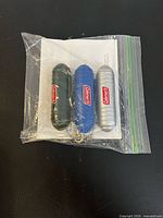 Three Coleman mosquito repellers with instruction sheet in zip bag