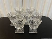 Seven Cape Cod pattern glasses grouped on surface