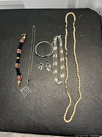 All seven costume jewelry pieces laid out