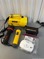Overall lot showing spotlight, two flashlights, alarm in bag, clock radio