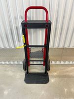 Front view of black and red convertible hand truck standing upright