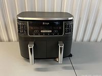 Front view showing digital controls, twin baskets, overall appearance
