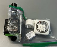Front view showing Logica water timer bagged with instruction sheet and Intermatic timer with accessories