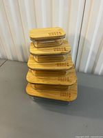 Stacked view of five glass containers with bamboo lids showing Urban Green logo
