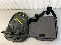 Grey backpack and grey messenger bag displayed side by side