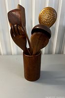 Wooden utensil set in cylindrical holder showing all six pieces