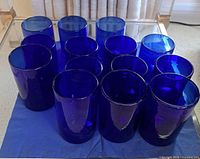 Group of 11 cobalt blue tumblers on blue cloth