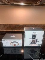 Two unopened Kuhn Rikon boxes: Vase Spice Grinder and six spice containers