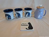 group shot of three cat mugs, tea jar and coaster