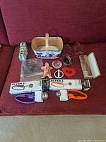 Overall lot view on couch showing all utensils, scoops, cutters and bake cups