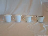 Four white ceramic FORLIFE tea infusers lined up