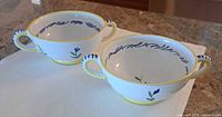 Both soup bowls angled to show handles, decoration and size