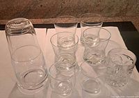 All items group view on cloth: carafe with tumbler lid and eight assorted lowball glasses