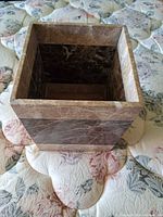 Perspective view of marble wastebasket showing exterior veining and band design