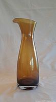 Front view of amber art glass carafe showing shape and clear base