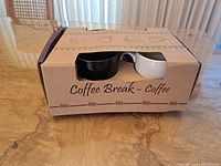 Closed box with BIA mugs visible through cut-out