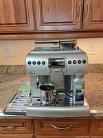 Front view of Philips Saeco espresso machine with accessories on countertop