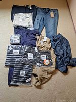 Overview of all nine clothing items laid out on floor