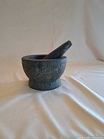 Mortar with pestle resting inside showing overall appearance