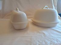 Round and oblong Superstone bread domes side by side on cloth backdrop