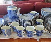 Overall view of stacked dinnerware with teapot and cups