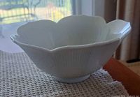 side view of a bowl showing scalloped rim and ribbed exterior