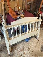 Front view of one Jenny Lind style headboard showing turned spindles, posts, paint wear