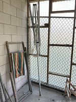 Full view of folded metal clothesline rack leaning against wall