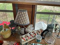 Shelf view showing bottle lamp, lantern, oil lamp, candy dish, planters, spice rack, enamelware kettle and coffee carafe