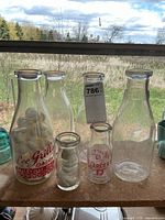 Six glass dairy bottles grouped: four quart, two small
