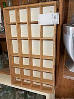 Front view of wooden display shelf showing compartments
