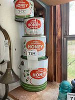 Stack of four Pure Canadian Honey tins showing three sizes