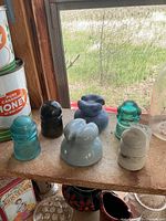 Shelf with six insulators in various materials and colors