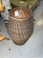 Full view of wicker hamper with lid on, side handles visible