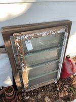 Two smaller painted windows stacked against larger stained window