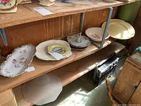 Shelf view showing assortment of serving dishes, plates and platter