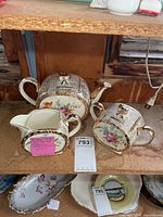 Teapot, sugar bowl and creamer grouped on shelf