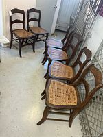 six matching wood chairs lined up side view